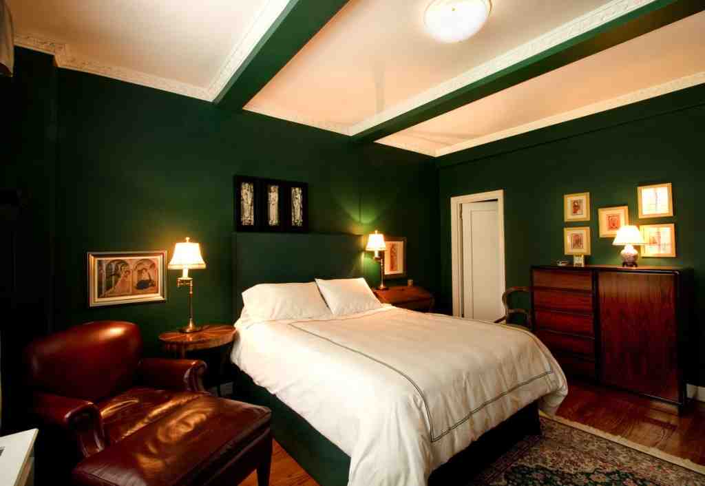 green bedroom with dark wood furniture